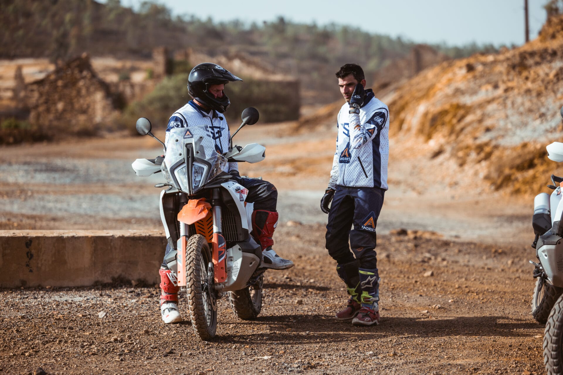 Rider on a KTM adventure bike talking with the guide during a stop at an old mine