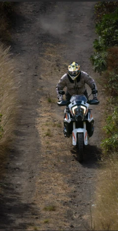 Rider on a KTM adventure bike on a rutted dirt track seen from above
