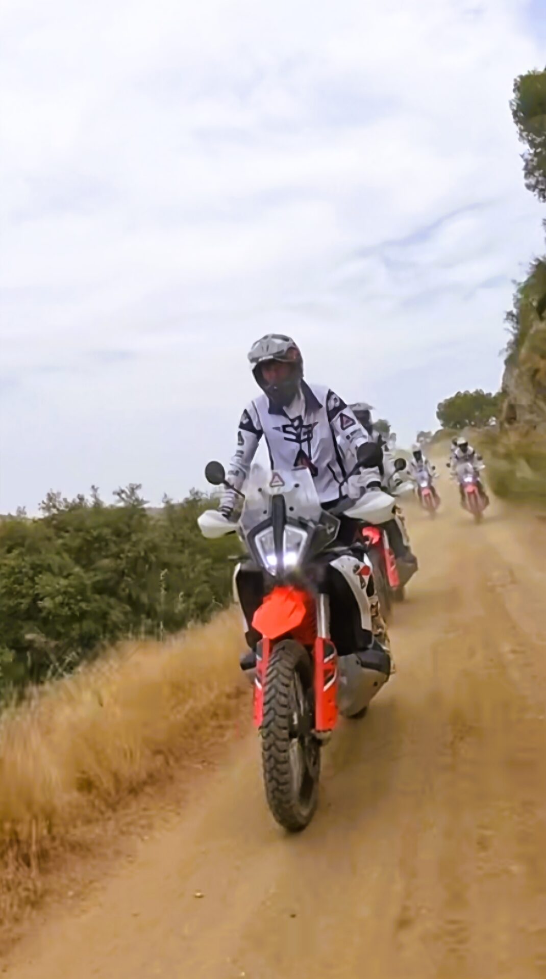 Rider on a KTM adventure bike leading the group along a sandy track