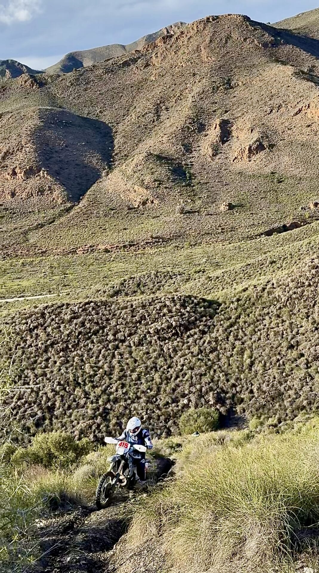 Enduro rider on a steep hillside trail in the bare mountains of Murcia