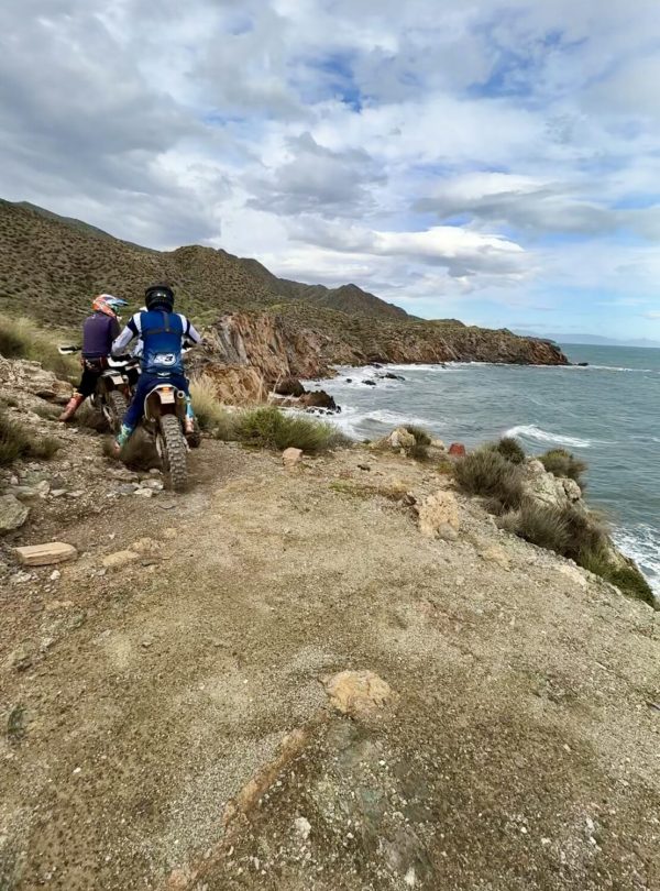 Enduro rider on a clifftop trail above the sea on the Mediterranean Enduro tour in Murcia