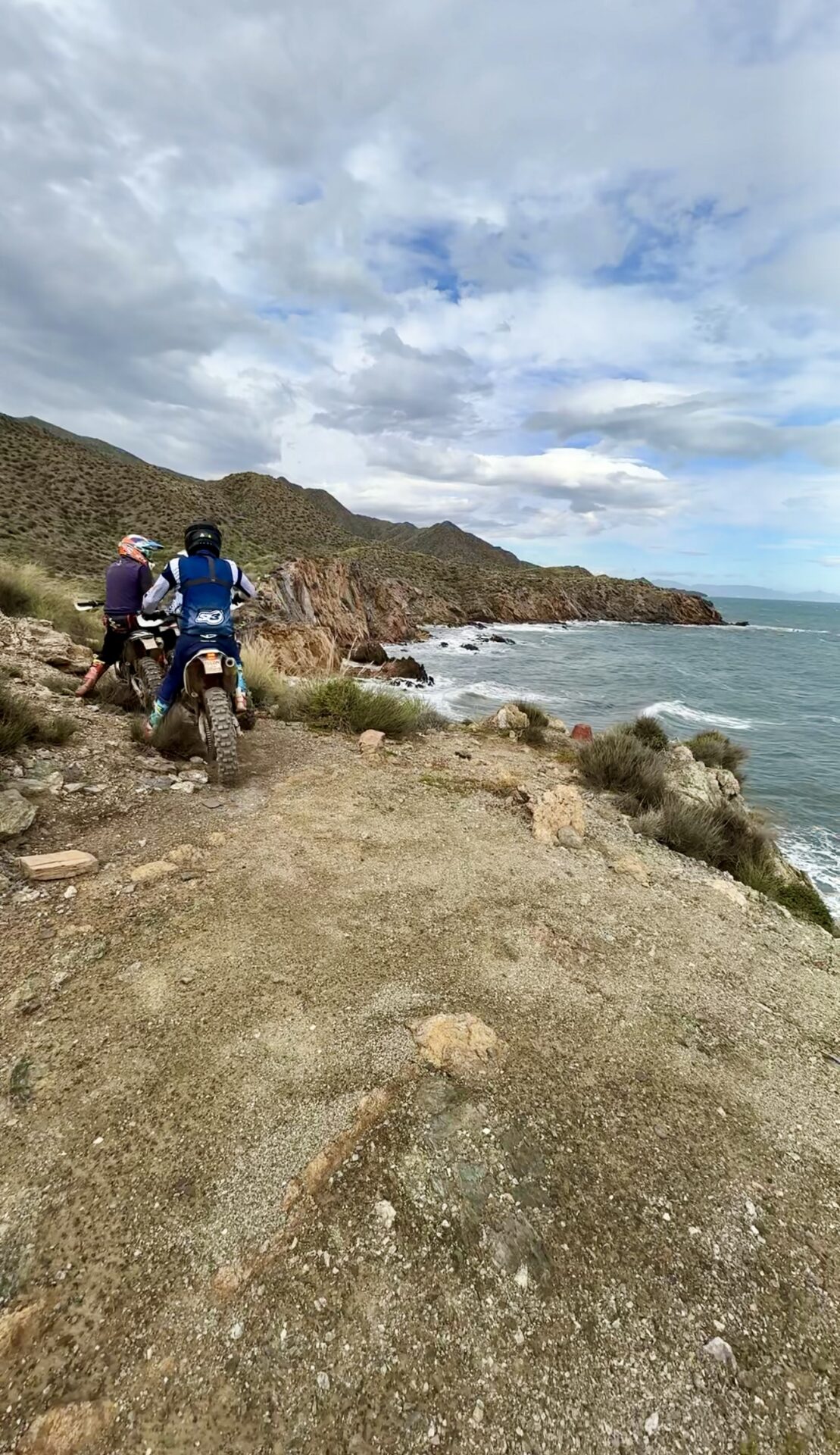 Enduro rider on a clifftop trail above the sea on the Mediterranean Enduro tour in Murcia