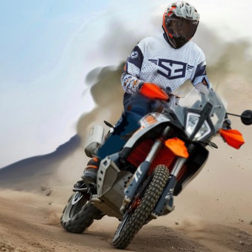Rider on a KTM adventure bike kicking up desert dust on the African Sahara Adventure tour