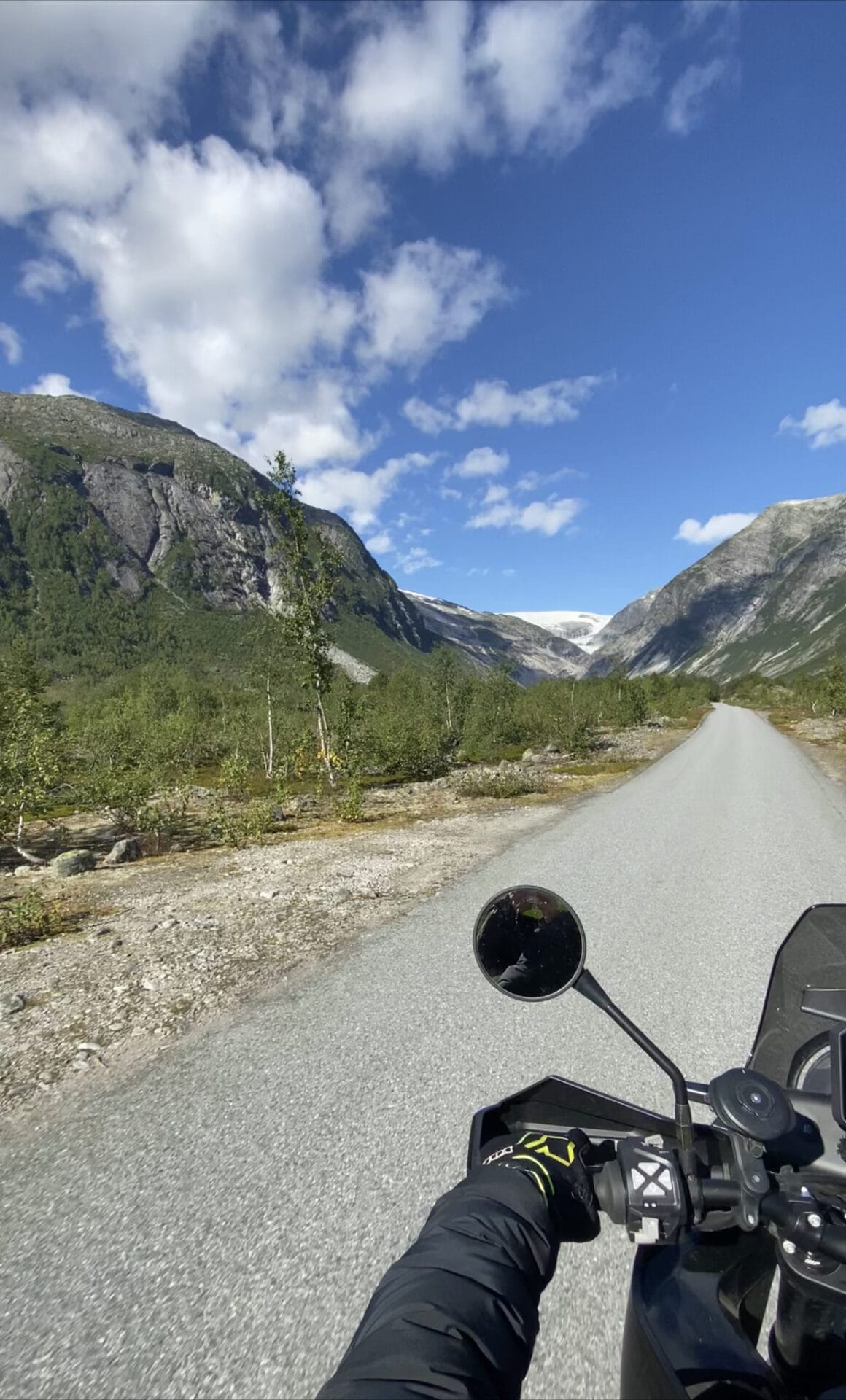 Rider's view along a quiet road through a mountain valley in Norway