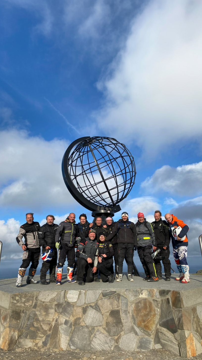 Group of riders at the globe monument on the North Cape, Norway