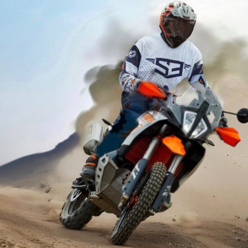 Rider on a KTM adventure bike kicking up dust at the KTM Spanish Meeting