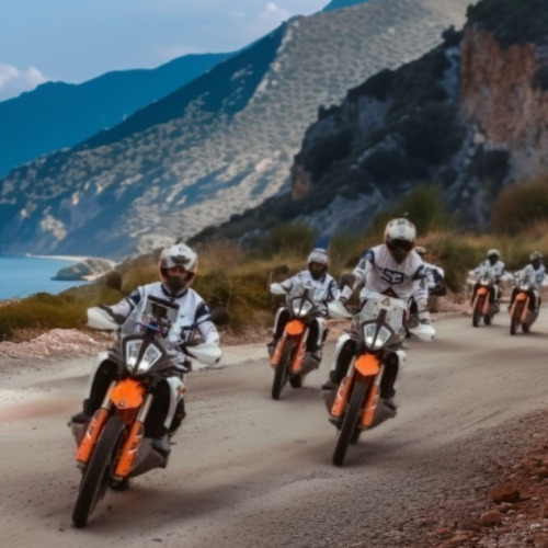 Group of riders on KTM adventure bikes on a coastal mountain road on the Northern Morocco tour
