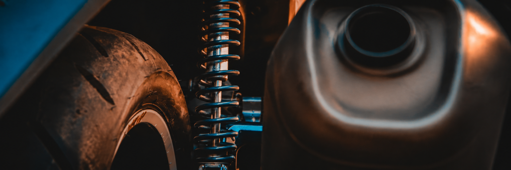 Close-up of a car wheel, coilover shock absorber and exhaust