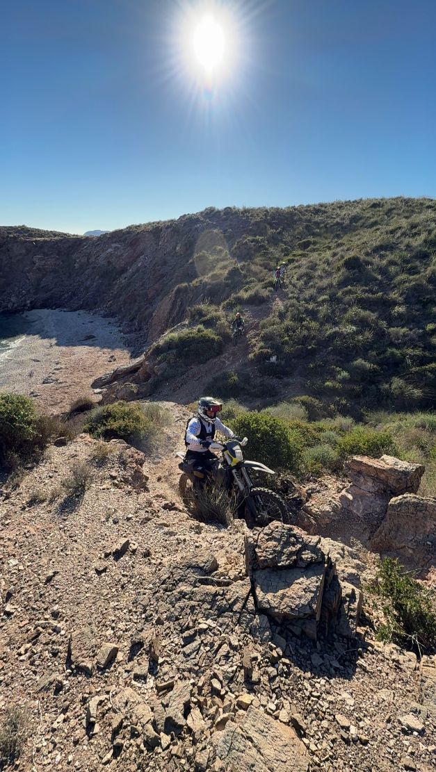 Enduro rider tackling a rocky descent in the coastal hills of Murcia