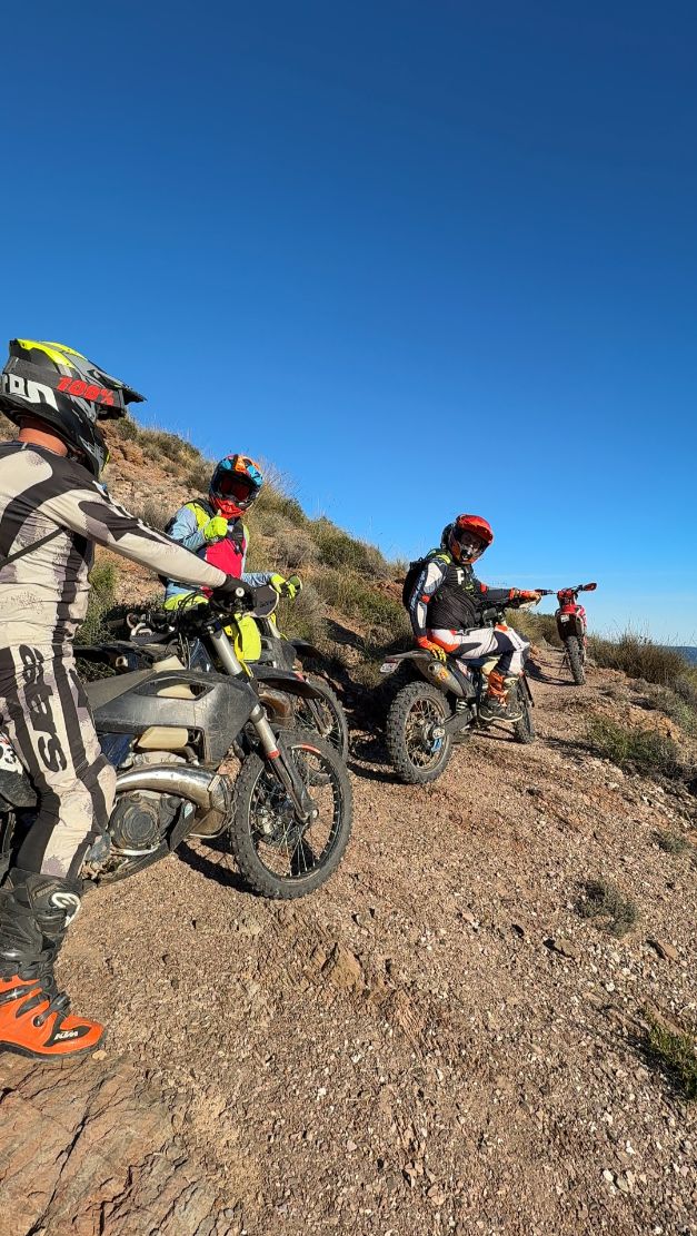 Enduro riders taking a break on a hillside trail in Murcia
