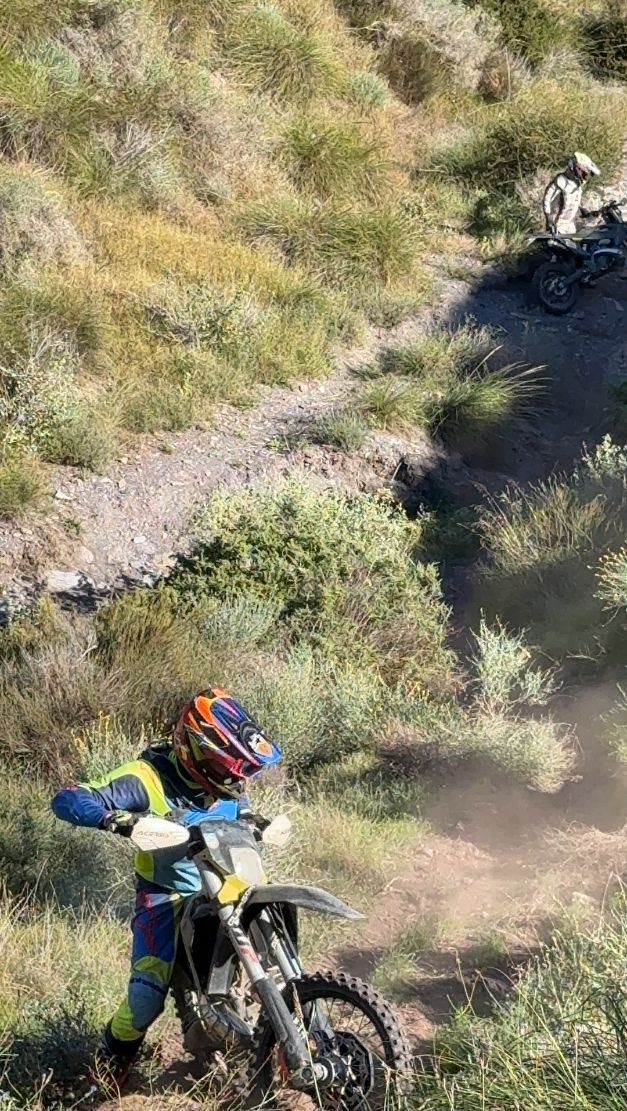 Enduro riders on a dusty singletrack through esparto grass