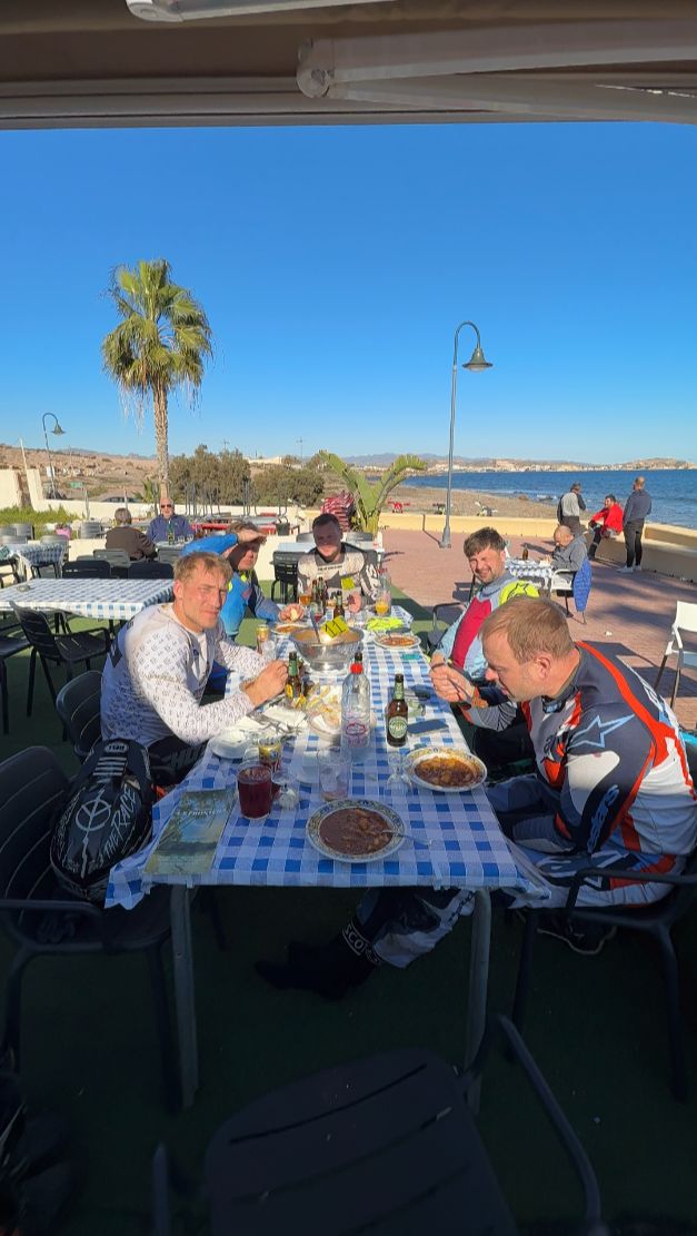 Enduro riders having lunch on a seaside terrace