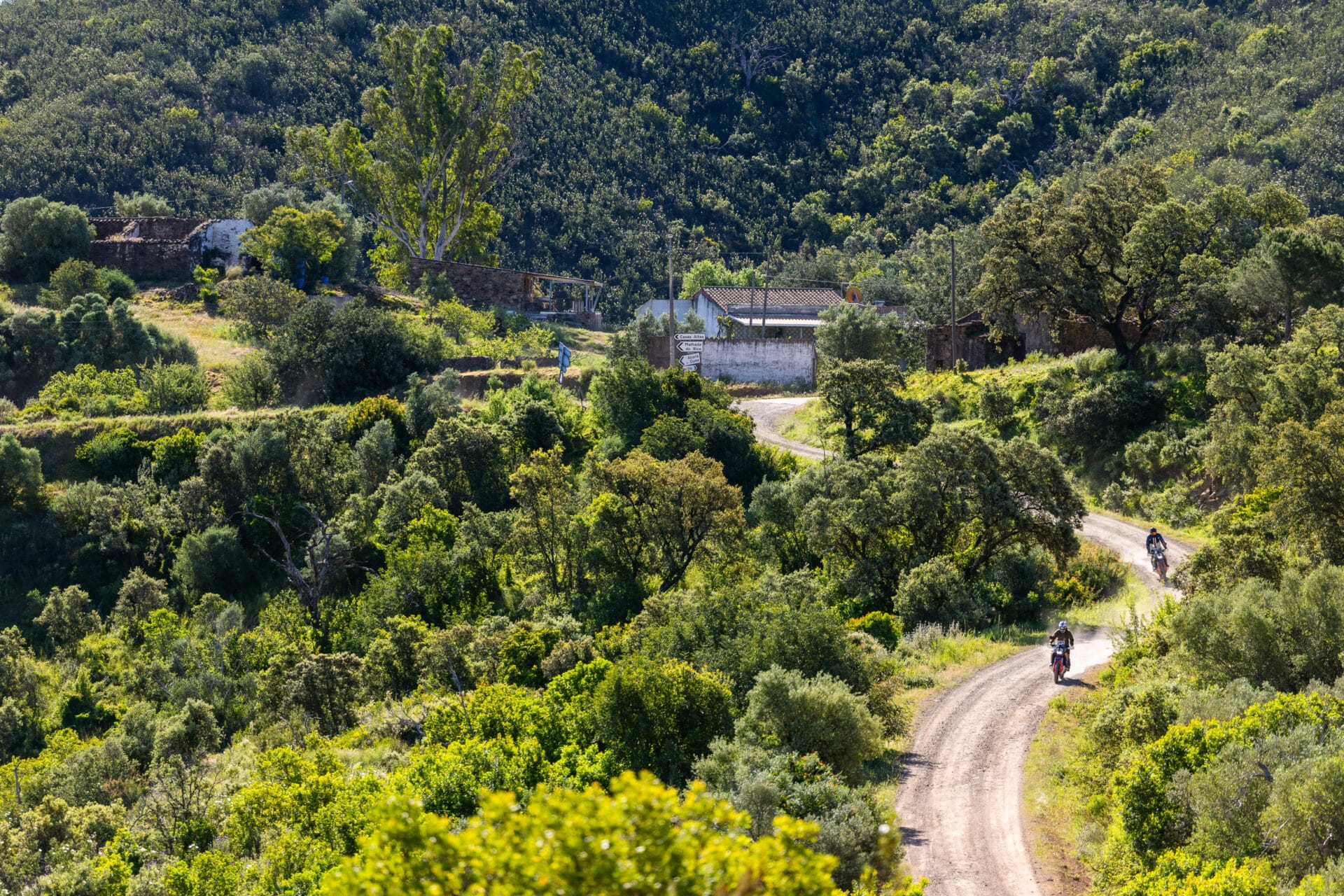 Riders on a dirt track through a green valley in the Portuguese interior
