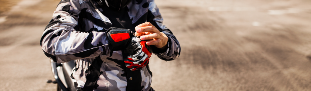 Rider in adventure motorcycle gear fastening his gloves
