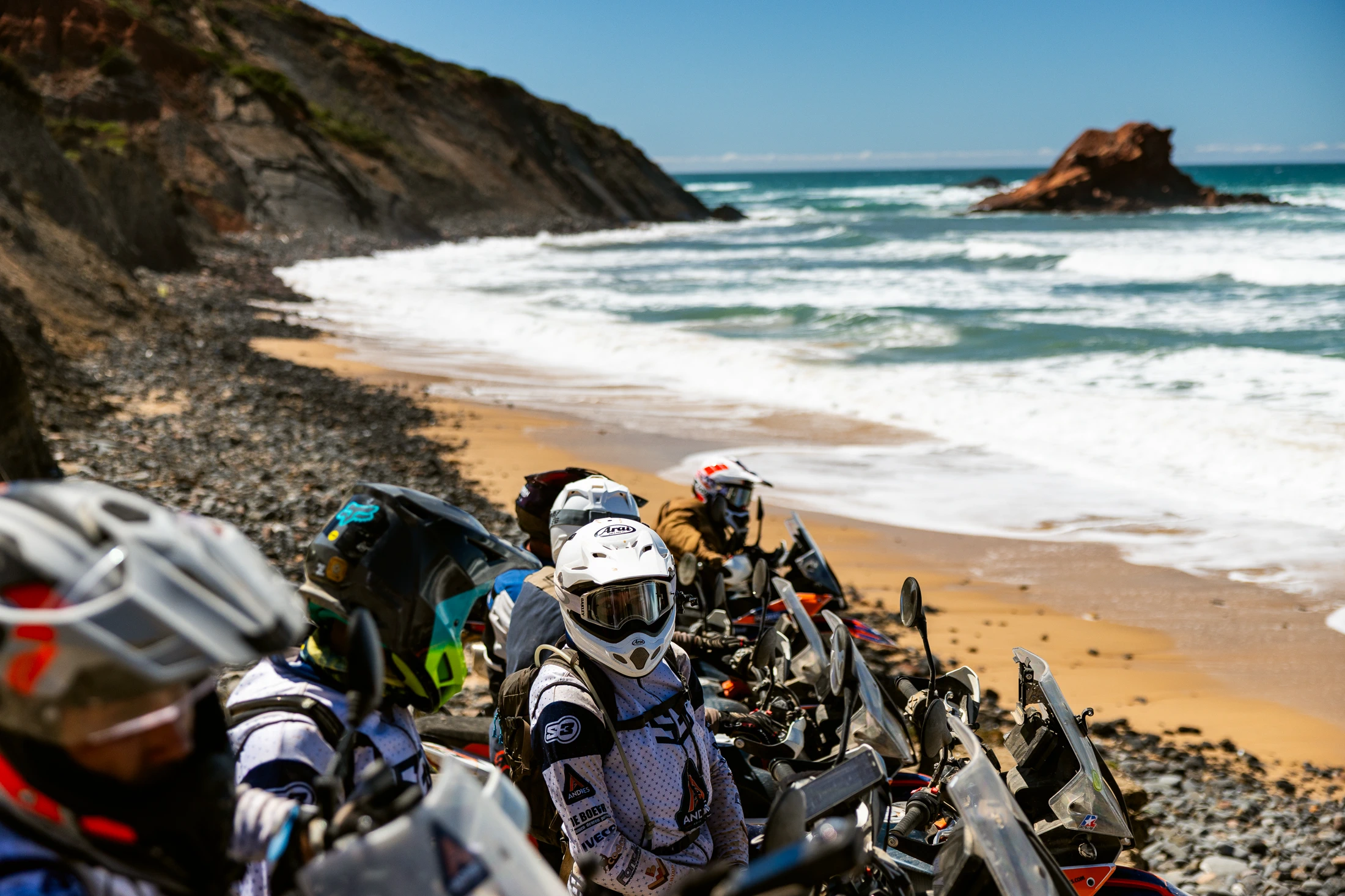 Riders taking a break on a rocky beach on the Algarve coast