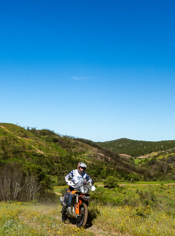 Rider on a KTM adventure bike in the green hills of Spain