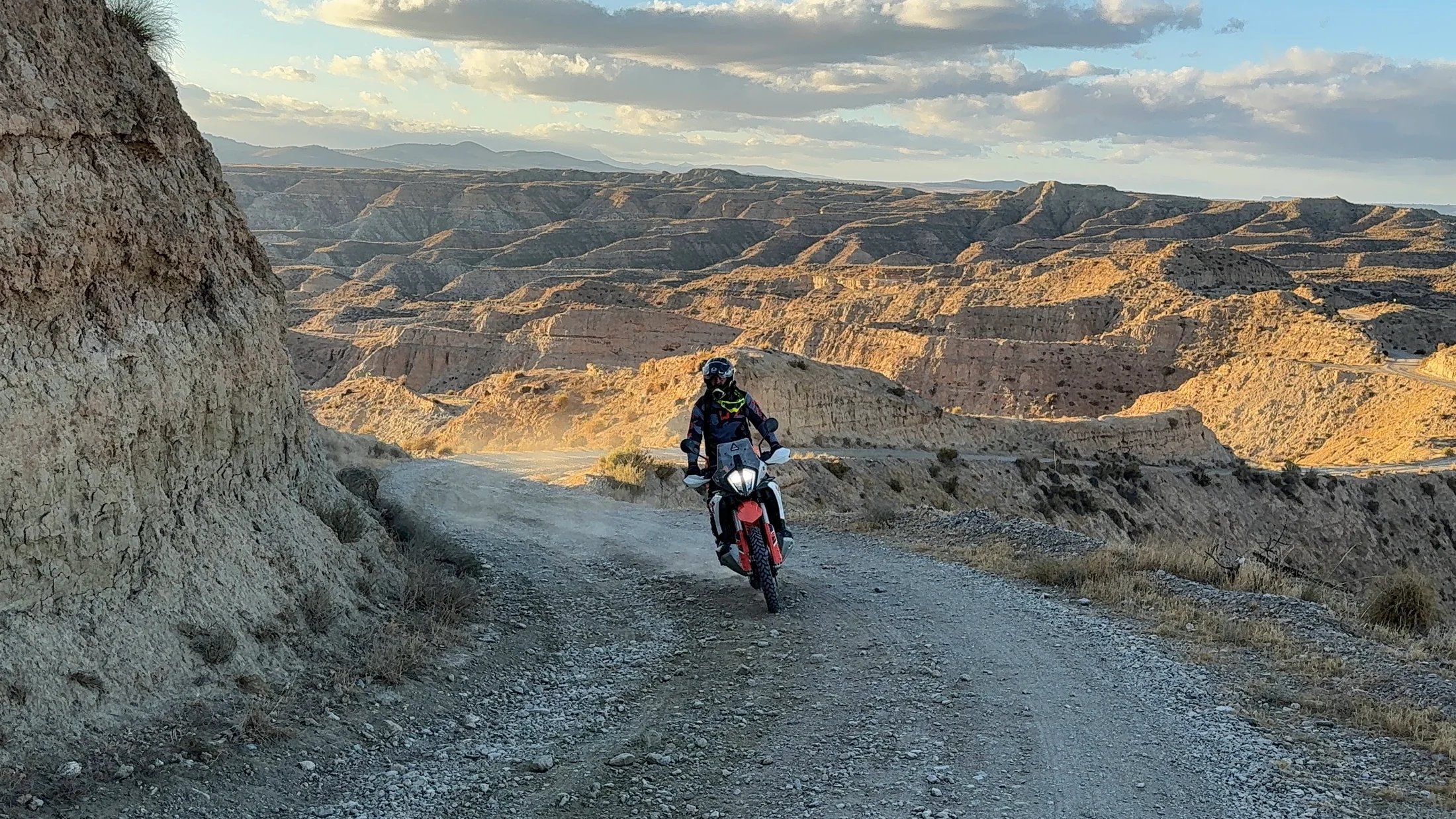 Rider on an adventure motorcycle on a gravel road through the badlands of the Gorafe desert