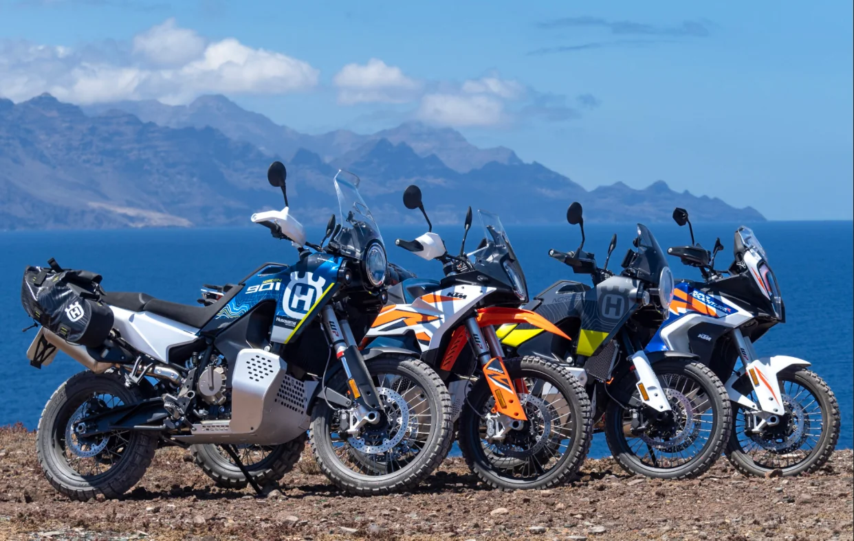 Husqvarna and KTM adventure motorcycles parked at a coastal viewpoint in the Canary Islands